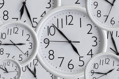 Çeşitli boyutlardaki beyaz analog ofis saatlerinin arka planı