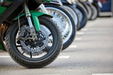 Otoparkta sıra sıra motorsiklet tekerlekleri. Yakın çekim, seçici odaklanma