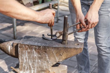 Demirci bir at nalı yapar. Yakın çekim, seçici odaklanma