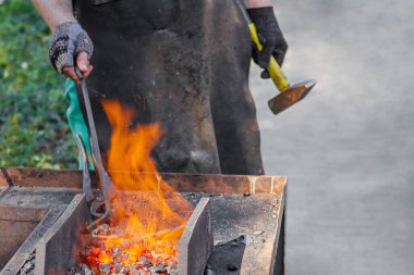 Demirci bir at nalı yapar. Yakın çekim, seçici odaklanma