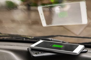 Telefon bataryası kablosuz şarj paylaşım teknolojisi. Yağmurlu havada arabada kablosuz şarj akıllı telefonu paylaşıyor