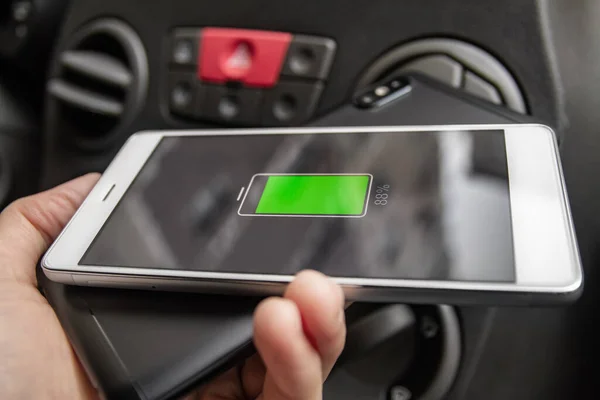 Phone battery wireless charge sharing technology. Wireless charge sharing smartphone in the car in rainy weather