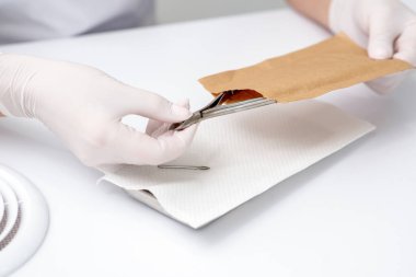 Manikürcünün elini kapat. Manikür salonundaki el işi zarfından manikür aletini çıkar..