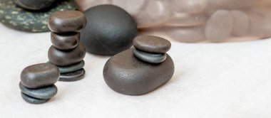 Spa salonundaki masanın üzerinde çeşitli masaj taşları var..