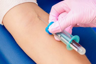 Hemşire el, koronavirüs aşısını tanıtıyor. Kadının koluna iğne batırıyor..