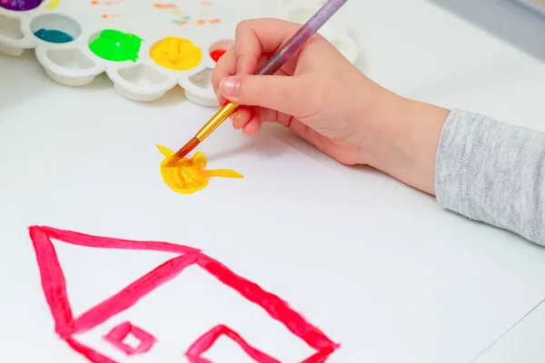 Kinderhand Zeichnet Die Sonne Neben Gezeichnetem Roten Haus Mit Aquarellen — Stockfoto