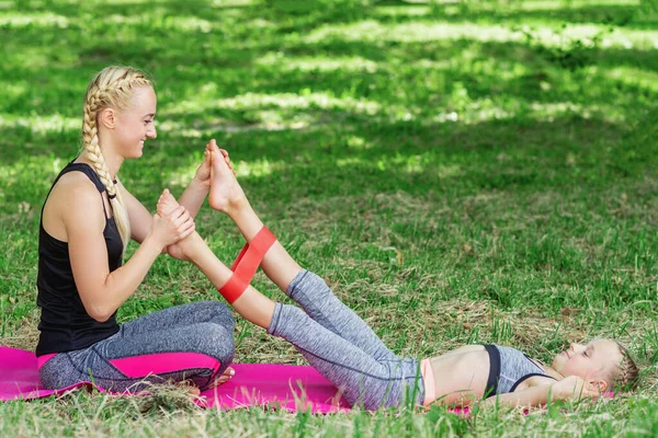 Молодая Женщина Тренирует Ноги Маленькой Девочки Помощью Жвачки Коврике Парке — стоковое фото