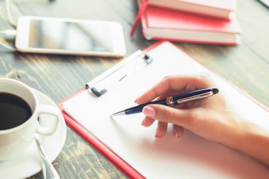 Boş bir ajandaya kalemle yazan bir iş kadınının elini kapat. İş konsepti.