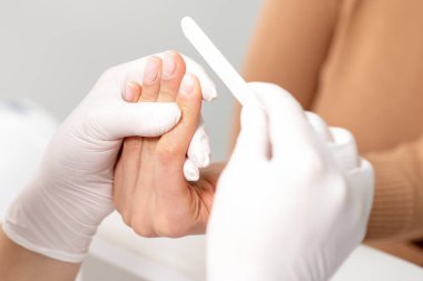 Manikür ustasının ellerini kapat. Tırnaklarını törpüle..