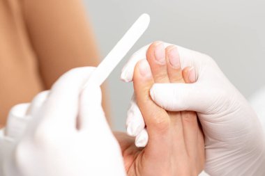 Manikür ustasının ellerini tırnak törpüsü ile manikür yaparken kapatın..