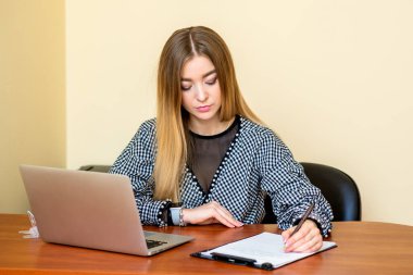 İş kadını ofisteki bilgisayarlı bir belgeye yazı yazıyor..