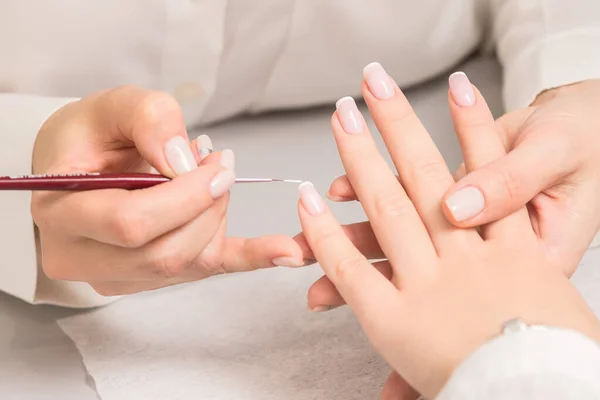 Mano Mujer Joven Recibiendo Manicura Francesa Por Esteticista Salón Uñas — Foto de Stock