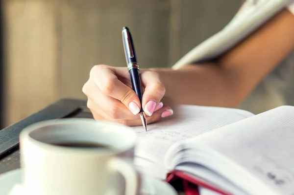 Mujer Negocios Mano Está Escribiendo Bloc Notas Con Pluma Cafetería — Foto de Stock