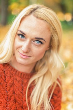 Güz Parkı 'nda kameraya bakan güzel sarı saçlı beyaz kadının portresi.