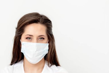 Beyaz arka planda tıbbi maskesi olan beyaz bir kadının portresi. Coronavirus konsepti