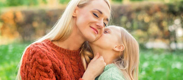 Bonito Filha Beija Sua Jovem Mãe Enquanto Está Sentado Parque — Fotografia de Stock