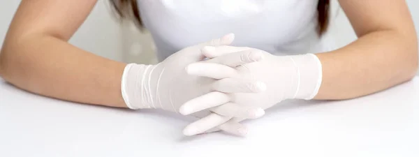 Manos Guantes Médicos Blancos Protectores Mujer Sentada Mesa Blanca Cruzado —  Fotos de Stock