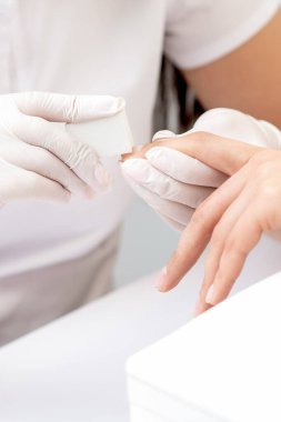 Manikürcüde manikürcü tarafından manikür yapılan kadına yakın çekim