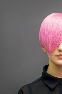 Kısa pembe saçlı, güzel, beyaz bir kadının portresi. Profesyonel saç boyama