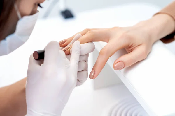 Manicure Master Rękawiczkach Ochronnych Stosujących Beżowy Lakier Paznokci Żeńskich Paznokciach — Zdjęcie stockowe