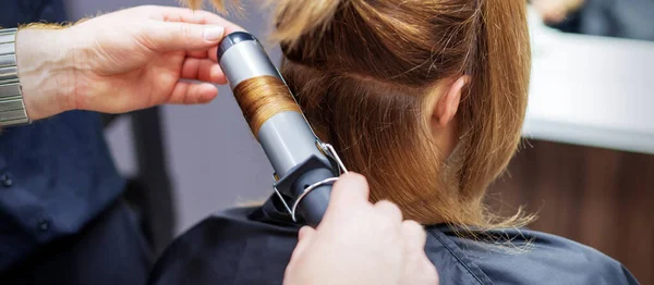 Professionele Kapper Wrijft Krullen Van Lange Lichtbruine Haren Van Vrouw — Stockfoto