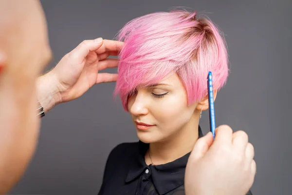 Kapper Controleren Korte Roze Kapsel Van Jonge Vrouw Grijze Achtergrond — Stockfoto