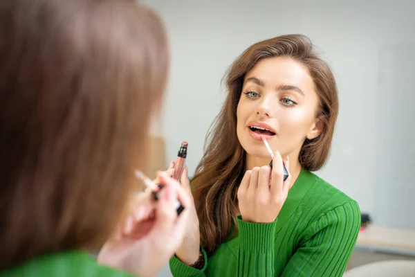 Vacker Ung Kaukasiska Kvinna Applicera Glans Läpparna Tittar Spegeln — Stockfoto