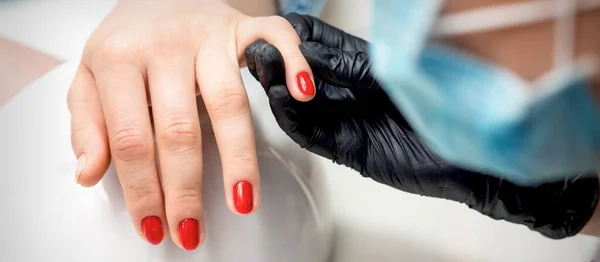 Jonge Vrouw Ontvangt Rode Nagel Lak Door Professionele Manicure Meester — Stockfoto