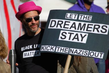 A man stands with a sign that says 