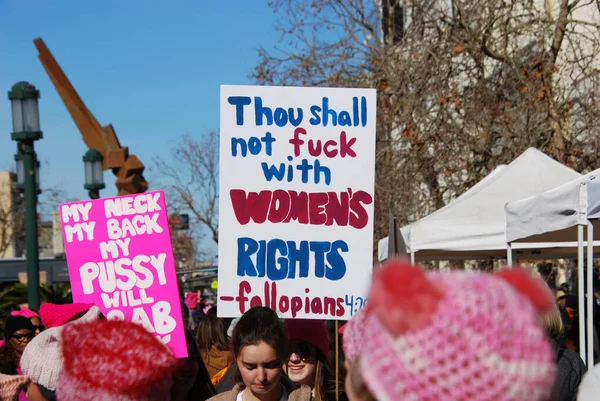 Women carry signs including 