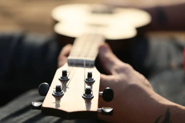 Playing a small guitar ukulele