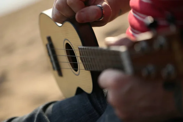 Playing a small guitar ukulele