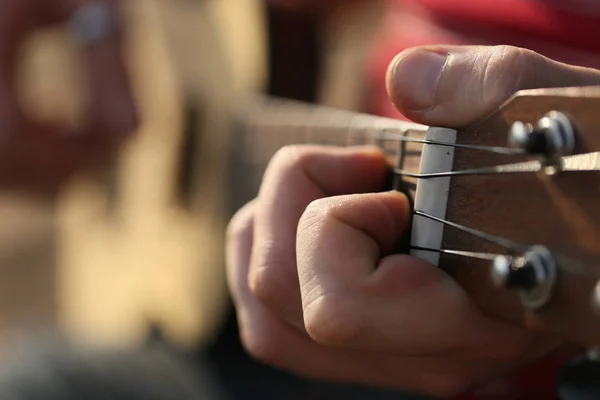 Playing a small guitar ukulele