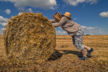 Kovboy şapkalı, buğday ekmekli, sakallı genç bir adam.