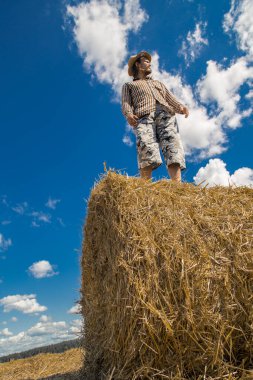 Kovboy şapkalı, buğday ekmekli, sakallı genç bir adam.