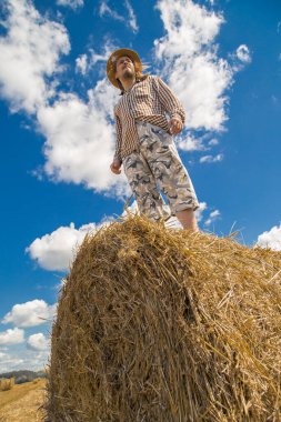 Kovboy şapkalı, buğday ekmekli, sakallı genç bir adam.