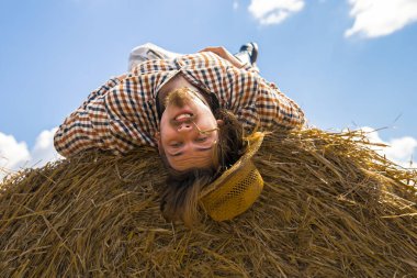 Kovboy şapkalı, buğday ekmekli, sakallı genç bir adam.