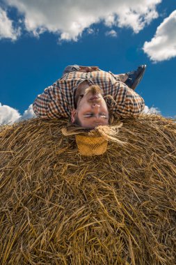 Kovboy şapkalı, buğday ekmekli, sakallı genç bir adam.