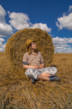 Kovboy şapkalı, buğday ekmekli, sakallı genç bir adam.