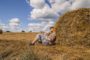 Kovboy şapkalı, buğday ekmekli, sakallı genç bir adam.