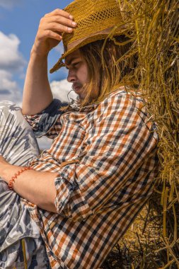 Kovboy şapkalı, buğday ekmekli, sakallı genç bir adam.