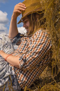 Kovboy şapkalı, buğday ekmekli, sakallı genç bir adam.