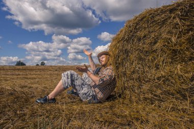 Kovboy şapkalı, buğday ekmekli, sakallı genç bir adam.