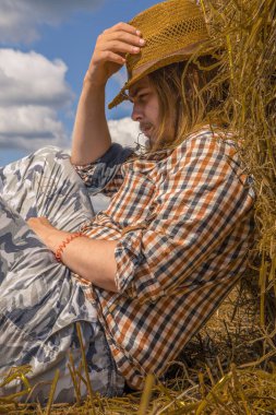 Kovboy şapkalı, buğday ekmekli, sakallı genç bir adam.