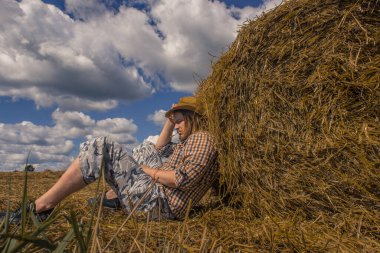 Kovboy şapkalı, buğday ekmekli, sakallı genç bir adam.