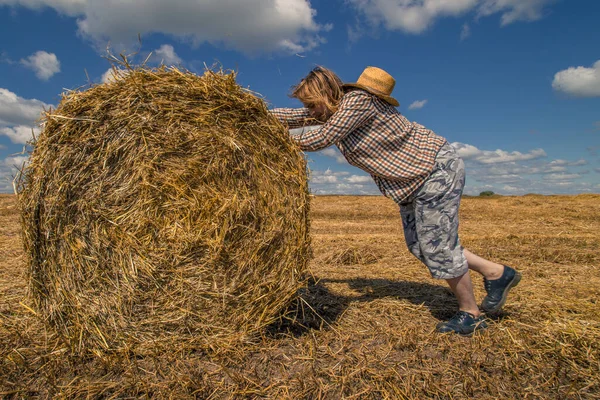 Kovboy şapkalı, buğday ekmekli, sakallı genç bir adam.