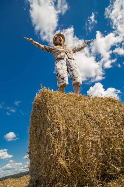 Kovboy şapkalı, buğday ekmekli, sakallı genç bir adam.