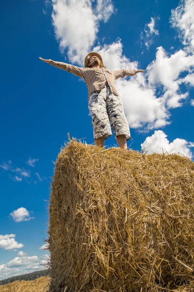 Kovboy şapkalı, buğday ekmekli, sakallı genç bir adam.