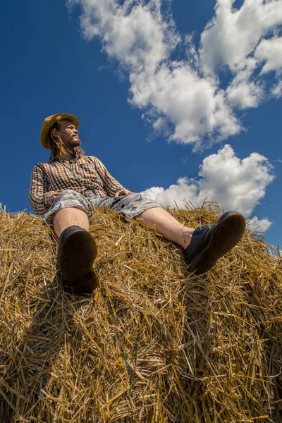 Kovboy şapkalı, buğday ekmekli, sakallı genç bir adam.