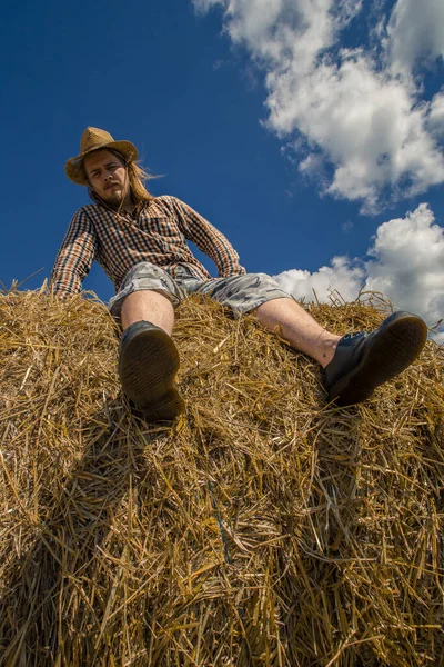 Kovboy şapkalı, buğday ekmekli, sakallı genç bir adam.